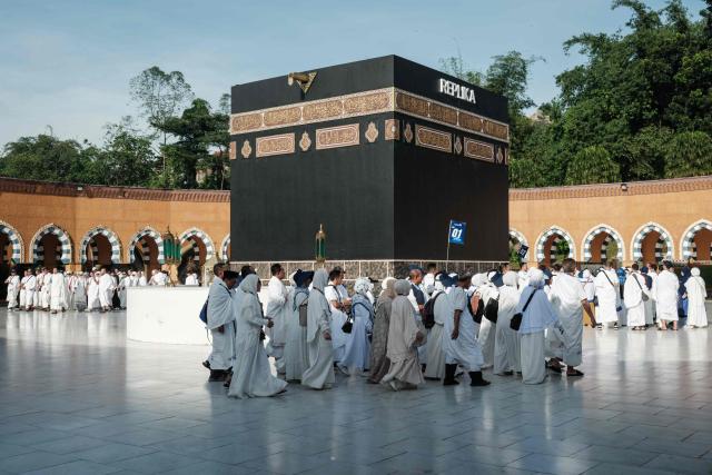 Prospective Indonesian pilgrims practice circumambulation rituals around a replica of the Kaaba, Islam’s holiest shrine, during a training session at the Al Mahmudah Manasik Training Center (AMTC) in South Tangerang on April 5, 2026. The centre provides a simulated experience of Mecca’s pilgrimage sites ahead of the Hajj season in late May. Indonesia, home to the world’s largest Muslim population, has been allocated a Hajj quota of 221,000 pilgrims for 2026, but faces long waiting lists that can stretch for decades in some regions. (Photo by YASUYOSHI CHIBA / AFP)