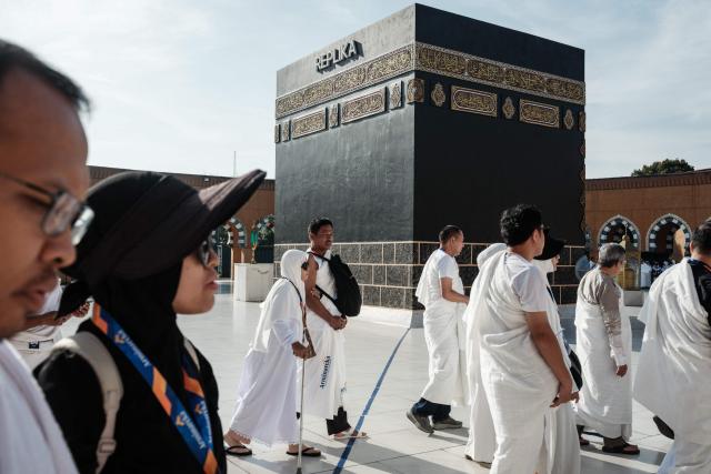 Prospective Indonesian pilgrims practice circumambulation rituals around a replica of the Kaaba, Islam’s holiest shrine, during a training session at the Al Mahmudah Manasik Training Center (AMTC) in South Tangerang on April 5, 2026. The centre provides a simulated experience of Mecca’s pilgrimage sites ahead of the Hajj season in late May. Indonesia, home to the world’s largest Muslim population, has been allocated a Hajj quota of 221,000 pilgrims for 2026, but faces long waiting lists that can stretch for decades in some regions. (Photo by YASUYOSHI CHIBA / AFP)