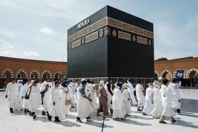 Prospective Indonesian pilgrims practice circumambulation rituals around a replica of the Kaaba, Islam’s holiest shrine, at the Al Mahmudah Manasik Training Center (AMTC), a Hajj training facility featuring replicas of key pilgrimage sites, in South Tangerang on April 5, 2026. The centre provides a simulated experience of Mecca’s pilgrimage sites ahead of the Hajj season in late May. Indonesia, home to the world’s largest Muslim population, has been allocated a Hajj quota of 221,000 pilgrims for 2026, but faces long waiting lists that can stretch for decades in some regions. (Photo by YASUYOSHI CHIBA / AFP)