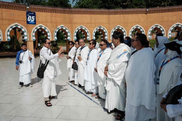 Prospective Indonesian pilgrims receive instruction as they practice rituals around a replica of the Kaaba, Islam’s holiest shrine, during a training session at the Al Mahmudah Manasik Training Center (AMTC) in South Tangerang on April 5, 2026. The centre provides a simulated experience of Mecca’s pilgrimage sites ahead of the Hajj season in late May. Indonesia, home to the world’s largest Muslim population, has been allocated a Hajj quota of 221,000 pilgrims for 2026, but faces long waiting lists that can stretch for decades in some regions. (Photo by YASUYOSHI CHIBA / AFP)
