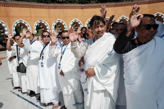Prospective Indonesian pilgrims practice rituals around a replica of the Kaaba, Islam’s holiest shrine, during a training session at the Al Mahmudah Manasik Training Center (AMTC) in South Tangerang on April 5, 2026. The centre provides a simulated experience of Mecca’s pilgrimage sites ahead of the Hajj season in late May. Indonesia, home to the world’s largest Muslim population, has been allocated a Hajj quota of 221,000 pilgrims for 2026, but faces long waiting lists that can stretch for decades in some regions. (Photo by YASUYOSHI CHIBA / AFP)