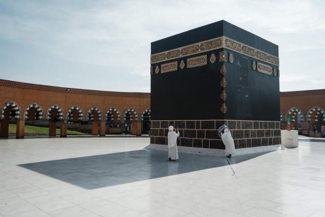 Muslim women take pictures in front of a replica of the Kaaba, Islam’s holiest shrine, at the Al Mahmudah Manasik Training Center (AMTC), a Hajj training facility featuring replicas of key pilgrimage sites, in South Tangerang on April 5, 2026. The centre provides a simulated experience of Mecca’s pilgrimage sites ahead of the Hajj season in late May. Indonesia, home to the world’s largest Muslim population, has been allocated a Hajj quota of 221,000 pilgrims for 2026, but faces long waiting lists that can stretch for decades in some regions. (Photo by YASUYOSHI CHIBA / AFP)