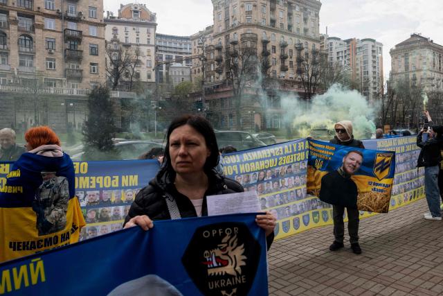 Relatives of missing Ukrainian soldiers hold flags, banners and photographs bearing the portraits of missing soldiers during a rally near Kyiv city council building, in Kyiv, on April 6, 2026, amid the Russian invasion of Ukraine. (Photo by Tetiana DZHAFAROVA / AFP)