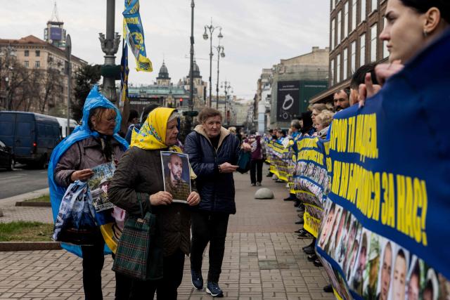 Relatives of missing Ukrainian soldiers hold flags, banners and photographs bearing the portraits of missing soldiers during a rally near Kyiv city council building, in Kyiv, on April 6, 2026, amid the Russian invasion of Ukraine. (Photo by Tetiana DZHAFAROVA / AFP)