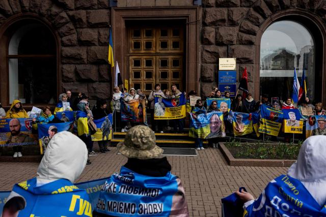 Relatives of missing Ukrainian soldiers hold flags, banners and photographs bearing the portraits of missing soldiers during a rally near Kyiv city council building, in Kyiv, on April 6, 2026, amid the Russian invasion of Ukraine. (Photo by Tetiana DZHAFAROVA / AFP)