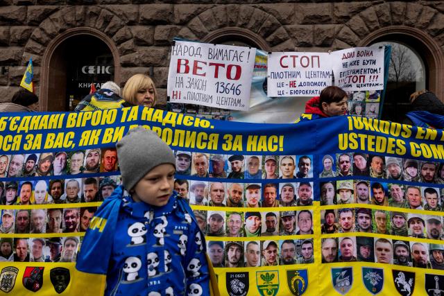 Relatives of missing Ukrainian soldiers hold flags, banners and photographs bearing the portraits of missing soldiers during a rally near Kyiv city council building, in Kyiv, on April 6, 2026, amid the Russian invasion of Ukraine. (Photo by Tetiana DZHAFAROVA / AFP)