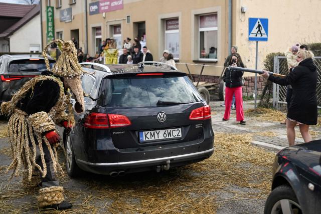 Polish bachelors wearing traditional straw costumes parade through the streets and splash water on the villagers in a ritual for fertility and a bountiful harvest as they celebrate Easter Monday in Dobra, Lesser Poland Voivodeship on April 6, 2026. (Photo by Sergei GAPON / AFP)