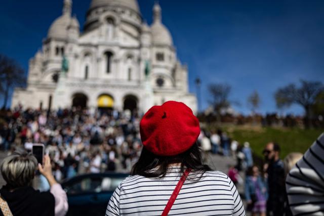 A pedestrian wearing a red beret climbs the steps leading to the entrance of the Sacre Coeur Basilica atop Montmartre hill, on Easter Monday in Paris on April 6, 2026. (Photo by Ian LANGSDON / AFP)