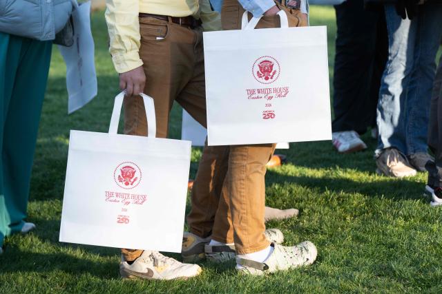 Guests hold gift bags as they attend the annual Easter Egg Roll on the South Lawn of the White House on April 6, 2026, in Washington, DC. (Photo by SAUL LOEB / AFP)