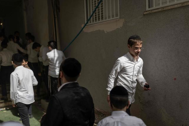 People gather to look at a building that was hit by an Iranian projectile attack in Bnei Brak in central Israel on April 6, 2026. Israeli strikes killed the intelligence chief of Iran's Revolutionary Guards, as the Islamic republic on April 6 defied threats from the US President to devastate civilian infrastructure if it does not reopen the Strait of Hormuz. (Photo by Ilia YEFIMOVICH / AFP) / 