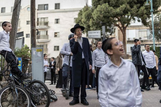 People gather to look at a building that was hit by an Iranian projectile attack in Bnei Brak in central Israel on April 6, 2026. Israeli strikes killed the intelligence chief of Iran's Revolutionary Guards, as the Islamic republic on April 6 defied threats from the US President to devastate civilian infrastructure if it does not reopen the Strait of Hormuz. (Photo by Ilia YEFIMOVICH / AFP) / 