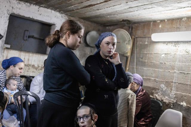 People take cover inside a bomb shelter in Bnei Brak in central Israel on April 6, 2026. Israeli strikes killed the intelligence chief of Iran's Revolutionary Guards, as the Islamic republic on April 6 defied threats from the US President to devastate civilian infrastructure if it does not reopen the Strait of Hormuz. (Photo by Ilia YEFIMOVICH / AFP) / 