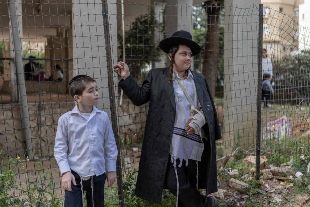 Young ultra-Orthodox Jewish boys gather to look at a building that was hit by an Iranian projectile attack in Bnei Brak in central Israel on April 6, 2026. Israeli strikes killed the intelligence chief of Iran's Revolutionary Guards, as the Islamic republic on April 6 defied threats from the US President to devastate civilian infrastructure if it does not reopen the Strait of Hormuz. (Photo by Ilia YEFIMOVICH / AFP) / 