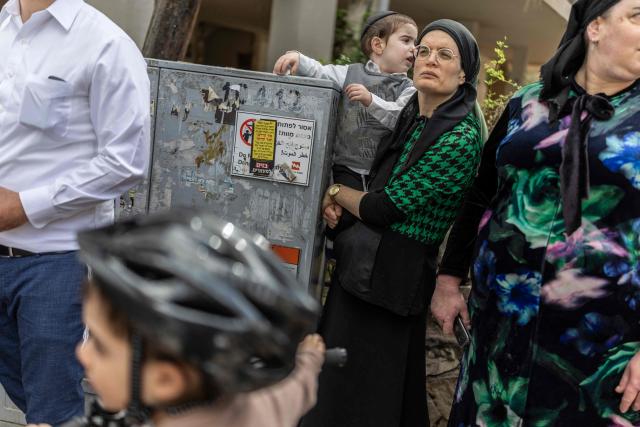 People gather to look at a building that was hit by an Iranian projectile attack in Bnei Brak in central Israel on April 6, 2026. Israeli strikes killed the intelligence chief of Iran's Revolutionary Guards, as the Islamic republic on April 6 defied threats from the US President to devastate civilian infrastructure if it does not reopen the Strait of Hormuz. (Photo by Ilia YEFIMOVICH / AFP) / 