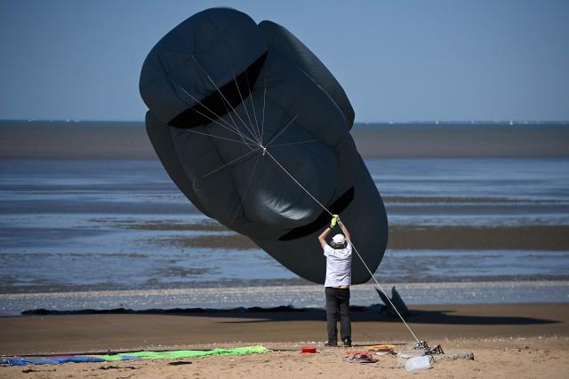 A participant holds his kite ont he beach during the international kite festival in Chatelaillon-Plage, south-western France, on April 6, 2026. (Photo by Christophe ARCHAMBAULT / AFP)