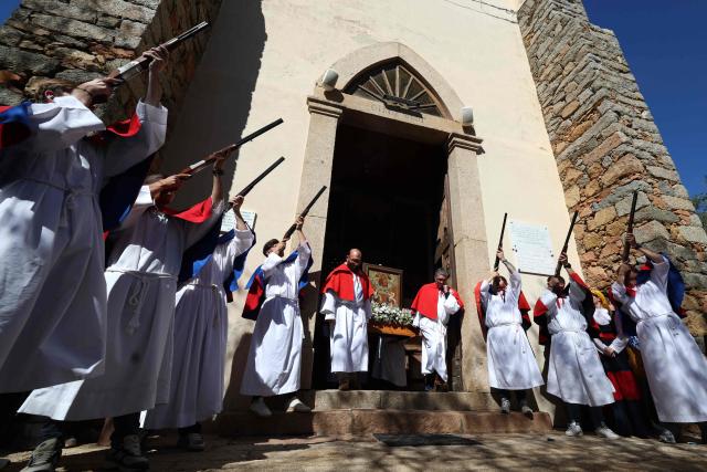 Brotherhood members shoot rifles outside the Saint Spyridon "Greek" church during a procession on Easter Monday in Cargese, the French Mediterranean island of Corsica, on April 6, 2026. (Photo by Pascal POCHARD-CASABIANCA / AFP)