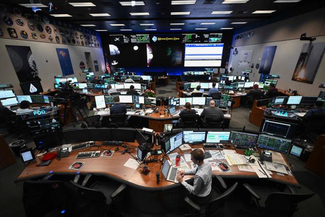 Artemis II flight controllers monitor the Orion spacecraft from the White Flight Control Room at Johnson Space Center in Houston, Texas, on April 6, 2026. The Artemis astronauts entered the final phase of their run-up to a lunar loop on Monday, a tipping point of sorts that means the Moon's gravity is now having a stronger pull on the spacecraft than Earth's. The Orion capsule will now whip around the Moon, setting the crew up to travel farther from our home planet than any human before. (Photo by RONALDO SCHEMIDT / AFP)