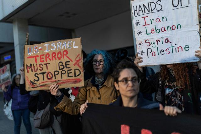 Israeli left-wing activists hold placards during a protest outside the US Embassy in Tel Aviv on April 6, 2026, against the ongoing war with Iran. The United States and Israel launched strikes against Iran on February 28, sparking swift retaliation by the Islamic republic which responded with missile attacks across the region. (Photo by Ilia YEFIMOVICH / AFP)