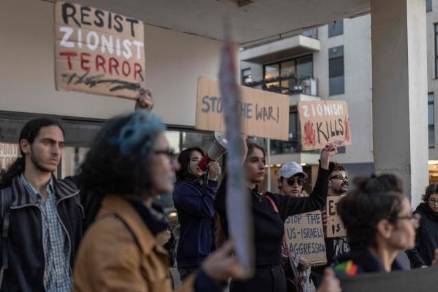 Israeli left-wing activists hold placards during a protest outside the US Embassy in Tel Aviv on April 6, 2026, against the ongoing war with Iran. The United States and Israel launched strikes against Iran on February 28, sparking swift retaliation by the Islamic republic which responded with missile attacks across the region. (Photo by Ilia YEFIMOVICH / AFP)