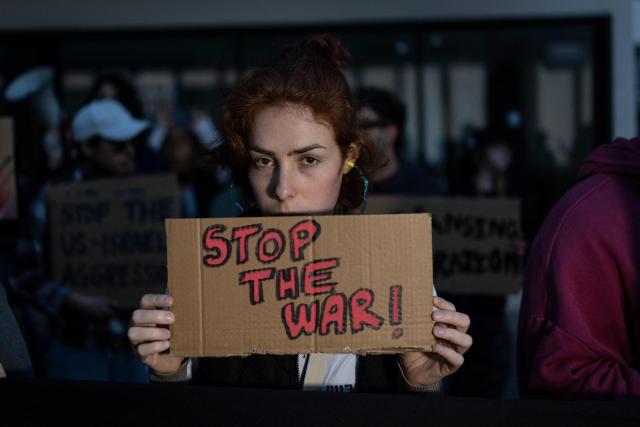 Israeli left-wing activists hold placards during a protest outside the US Embassy in Tel Aviv on April 6, 2026, against the ongoing war with Iran. The United States and Israel launched strikes against Iran on February 28, sparking swift retaliation by the Islamic republic which responded with missile attacks across the region. (Photo by Ilia YEFIMOVICH / AFP)