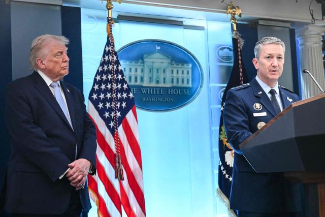 US President Donald Trump looks on as Chairman of the Joint Chiefs of Staff General Dan Caine speaks about the conflict in Iran in the James S. Brady Press Briefing Room of the White House on April 6, 2026, in Washington, DC. (Photo by SAUL LOEB / AFP)