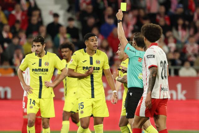 Spanish referee Adrian Cordero presents a yellow card to Villarreal's Uruguayan defender #15 Santiago Mourino during the Spanish league football match between Girona FC and Villarreal CF at Montilivi Stadium in Girona on April 6, 2026. (Photo by Lluis GENE / AFP)