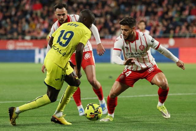 Villarreal's Ivorian forward #19 Nicolas Pepe and Girona's Spanish defender #24 Alexandre Moreno fight for the ball during the Spanish league football match between Girona FC and Villarreal CF at Montilivi Stadium in Girona on April 6, 2026. (Photo by Lluis GENE / AFP)