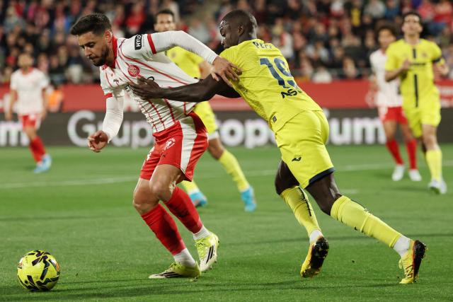 Girona's Spanish defender #24 Alexandre Moreno (L) and Villarreal's Ivorian forward #19 Nicolas Pepe fight for the ball during the Spanish league football match between Girona FC and Villarreal CF at Montilivi Stadium in Girona on April 6, 2026. (Photo by Lluis GENE / AFP)