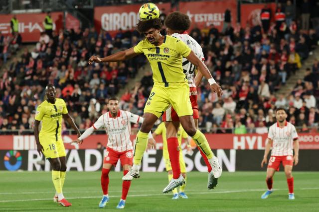 Villarreal's Portuguese defender #12 Renato Veiga wins a header against Girona's Belgian defender #20 Axel Witsel during the Spanish league football match between Girona FC and Villarreal CF at Montilivi Stadium in Girona on April 6, 2026. (Photo by Lluis GENE / AFP)