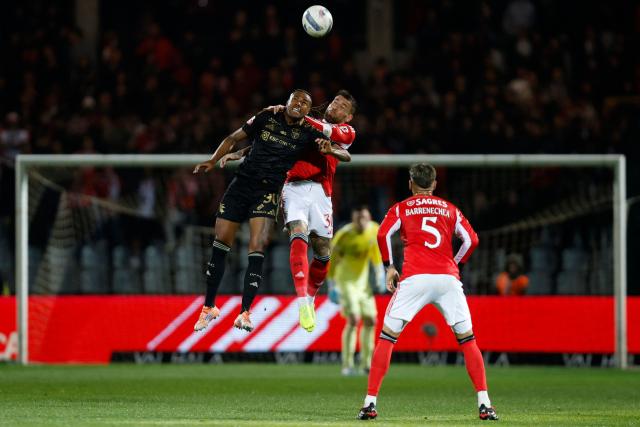 Casa Pia's Brazilian forward #90 Cassiano and SL Benfica's Argentine defender #30 Nicolas Otamendi vie for a header during the Portuguese League football match between Casa Pia AC and SL Benfica at Rio Maior Municipal Stadium on April 6, 2026. (Photo by FILIPE AMORIM / AFP)
