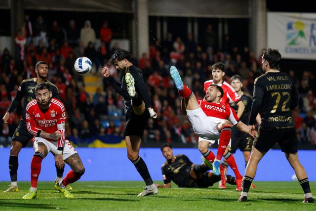 Casa Pia's Portuguese defender #04 Joao Goulart (3L) and SL Benfica's Greek forward #14 Vangelis Pavlidis (4R) fight for the ball during the Portuguese League football match between Casa Pia AC and SL Benfica at Rio Maior Municipal Stadium on April 6, 2026. (Photo by FILIPE AMORIM / AFP)
