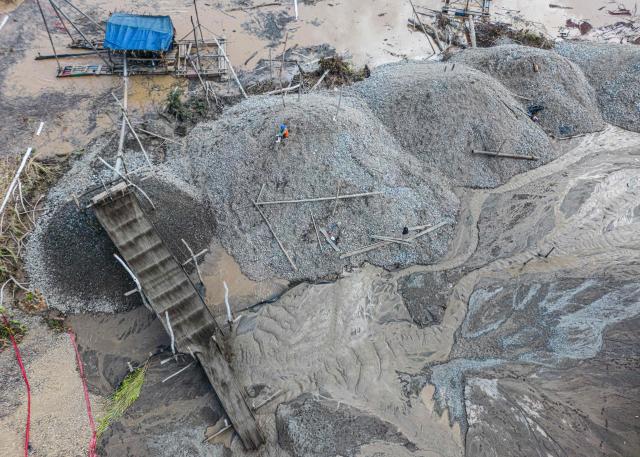 (FILES) Aerial picture of dredges at an illegal gold mining area in the Madre de Dios department, in Peru's southeastern Amazon region, on June 1, 2024. With a record 35 candidates running in the upcoming presidential election on April 12, 2026, Peru—rich in mineral resources, renowned gastronomy, and invaluable archaeological heritage—has also long been affected by internal conflict involving the Shining Path and the Tupac Amaru Revolutionary Movement. Since 2016, the country has faced chronic political instability, marked by a succession of eight different heads of state. (Photo by ERNESTO BENAVIDES / AFP)