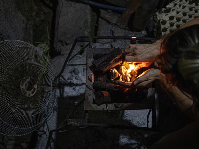 A woman prepares a wood fire to cook food during a blackout in Matanzas, Cuba, on April 6, 2026. Matanzas is one of the Cuban cities most affected by electricity shortages, at times going more than 24 hours without power, despite being home to the Antonio Guiteras Thermoelectric Plant, one of the country’s most important. (Photo by AFP)