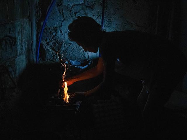 A woman prepares a wood fire to cook food during a blackout in Matanzas, Cuba, on April 6, 2026. Matanzas is one of the Cuban cities most affected by electricity shortages, at times going more than 24 hours without power, despite being home to the Antonio Guiteras Thermoelectric Plant, one of the country’s most important. (Photo by AFP)