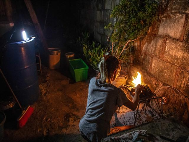 A woman prepares a wood fire to cook food during a blackout in Matanzas, Cuba, on April 6, 2026. Matanzas is one of the Cuban cities most affected by electricity shortages, at times going more than 24 hours without power, despite being home to the Antonio Guiteras Thermoelectric Plant, one of the country’s most important. (Photo by AFP)