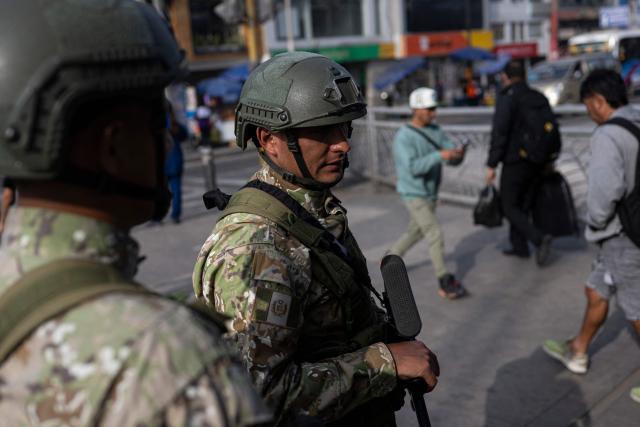 (FILES) Military officers patrol a street after the government declared a state of emergency in Lima on October 22, 2025. After a succession of short-lived presidencies, Peruvians will choose on April 12, 2026, from a record 35 candidates to elect their new leader, who will govern a country gripped by organized crime and chronic political instability. (Photo by ERNESTO BENAVIDES / AFP)