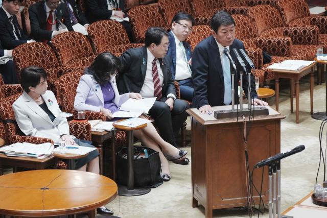 Japan's Foreign Minister Toshimitsu Motegi answers questions about the situation in the Middle East at a budget committee session of the House of Councillors at Parliament in Tokyo on April 7, 2026 while Prime Minister Sanae Takaichi (L) looks on. (Photo by Kazuhiro NOGI / AFP)
