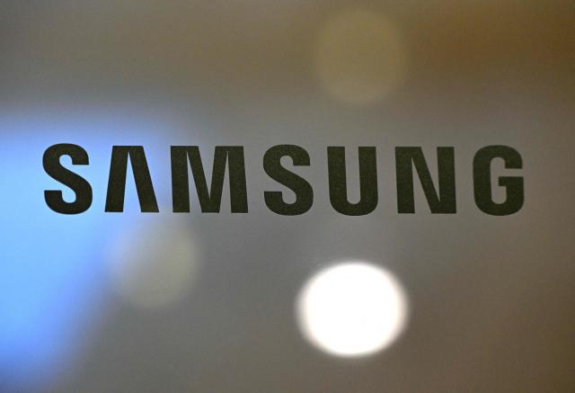 The logo of Samsung Electronics is displayed on a glass door at the company's Seocho building in Seoul on April 7, 2026. Tech giant Samsung Electronics estimated on April 7 that its first quarter profit had soared 755 percent annually to a record high of 57.2 trillion won (37.9 billion USD), driven by strong sales of chips crucial for artificial intelligence. (Photo by Jung Yeon-je / AFP)
