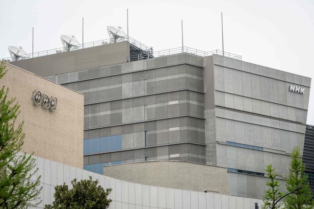 Logos of Japanese broadcasting corporation NHK are seen outside the NHK Broadcasting Center in Tokyo on April 7, 2026. Iran freed a Japanese national held since January, Tokyo said on April 7, with Kyodo News reporting that the person was believed to be the Tehran bureau chief of broadcaster NHK. (Photo by Yuichi YAMAZAKI / AFP)