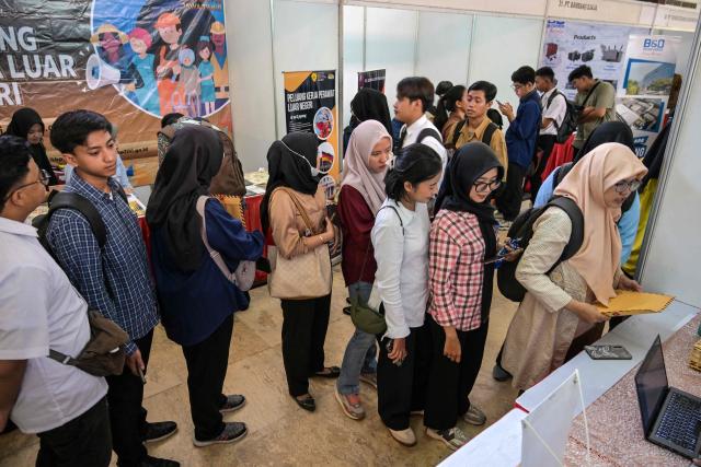 Job seekers queue to register at a jobs fair in Surabaya on April 7, 2026. (Photo by JUNI KRISWANTO / AFP)