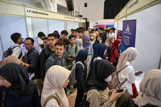 Job seekers register at a jobs fair in Surabaya on April 7, 2026. (Photo by JUNI KRISWANTO / AFP)
