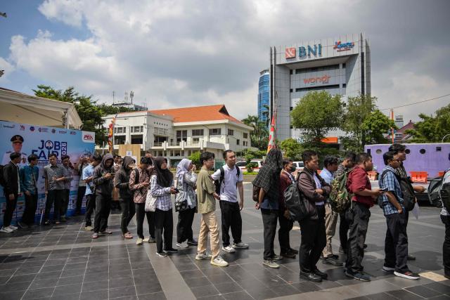 Job seekers queue to register at a jobs fair in Surabaya on April 7, 2026. (Photo by JUNI KRISWANTO / AFP)