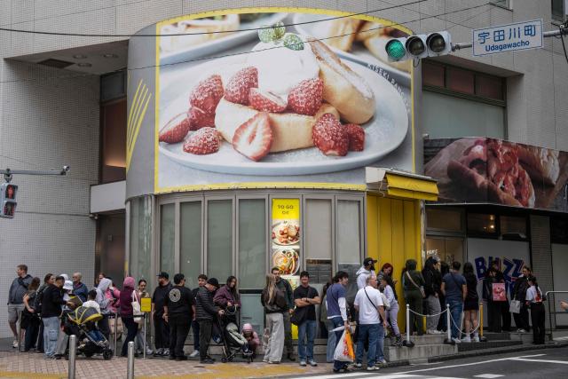 Foreign tourists stand in line in front of a pancake shop in Tokyo on April 7, 2026. (Photo by Yuichi YAMAZAKI / AFP)
