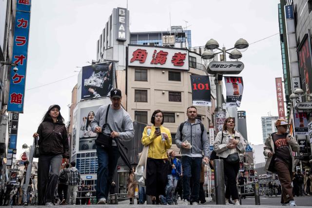 People walk through the Shibuya area in Tokyo on April 7, 2026. (Photo by Yuichi YAMAZAKI / AFP)
