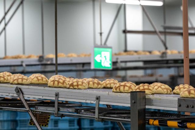 Semi-finished Melonpan are seen on the production line during a media tour at the factory of Garden Bakery in Akishima city, the western portion of the Tokyo Metropolis on April 7, 2026. (Photo by Philip FONG / AFP)