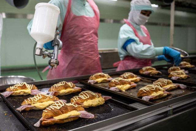 Staff member prepare the ingredients for the pork bacon and egg filling croissant during a media tour at the factory of Garden Bakery in Akishima city, the western portion of the Tokyo Metropolis on April 7, 2026. (Photo by Philip FONG / AFP)