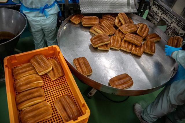 Staff members prepare the bread during a media tour at the factory of Garden Bakery in Akishima city, the western portion of the Tokyo Metropolis on April 7, 2026. (Photo by Philip FONG / AFP)