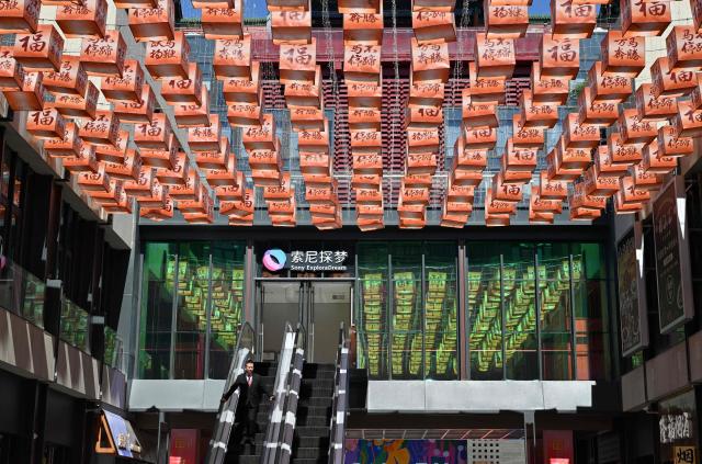 A man visits a shopping center in Beijing on April 7, 2026. (Photo by ADEK BERRY / AFP)