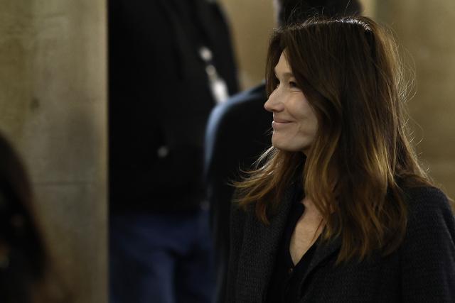 Carla Bruni-Sarkozy, wife of France's former president Nicolas Sarkozy, leaves the courtroom during the appeal trial of her husband over charges he sought Libyan financing for his 2007 election, at the Palais de Justice courthouse in Paris on April 7, 2026. The Paris Criminal Court in September 2025 convicted Sarkozy of criminal conspiracy and handed him a 5-year prison sentence over what it said was a scheme to acquire funding from Muammar Gaddafi's Libya for his 2007 presidential run that saw him elected. The right-wing politician -- who has denied any wrongdoing -- entered a Paris jail in October 2025, serving 20 days before he was released under judicial supervision. (Photo by Kenzo TRIBOUILLARD / AFP)