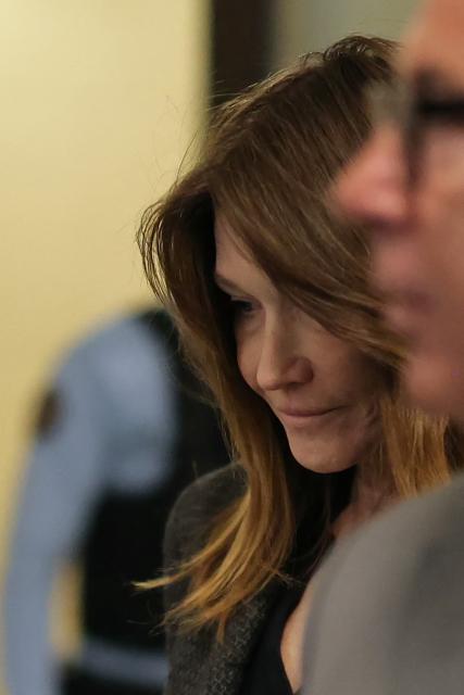 Carla Bruni-Sarkozy, wife of France's former president Nicolas Sarkozy, returns to the courtroom during the appeal trial of her husband over charges he sought Libyan financing for his 2007 election, at the Palais de Justice courthouse in Paris on April 7, 2026. The Paris Criminal Court in September 2025 convicted Sarkozy of criminal conspiracy and handed him a 5-year prison sentence over what it said was a scheme to acquire funding from Muammar Gaddafi's Libya for his 2007 presidential run that saw him elected. The right-wing politician -- who has denied any wrongdoing -- entered a Paris jail in October 2025, serving 20 days before he was released under judicial supervision. (Photo by Thomas SAMSON / AFP)